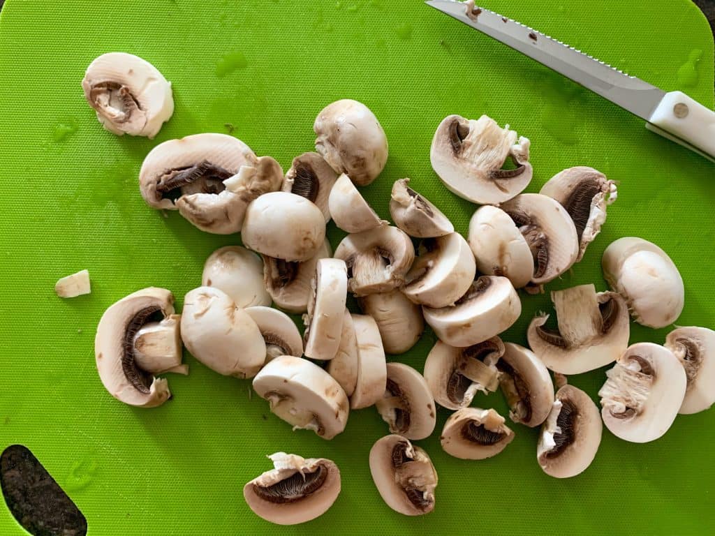 sliced mushrooms on a green cutting board